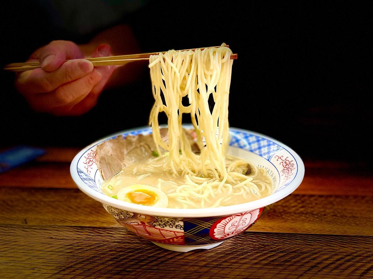 Noodles lifted from a bowl of tonkotsu