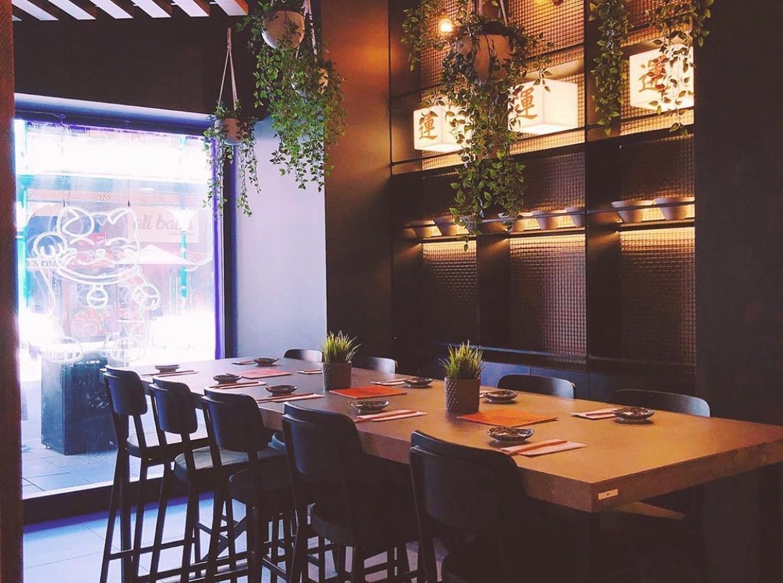 Tables under hanging plants and lanterns